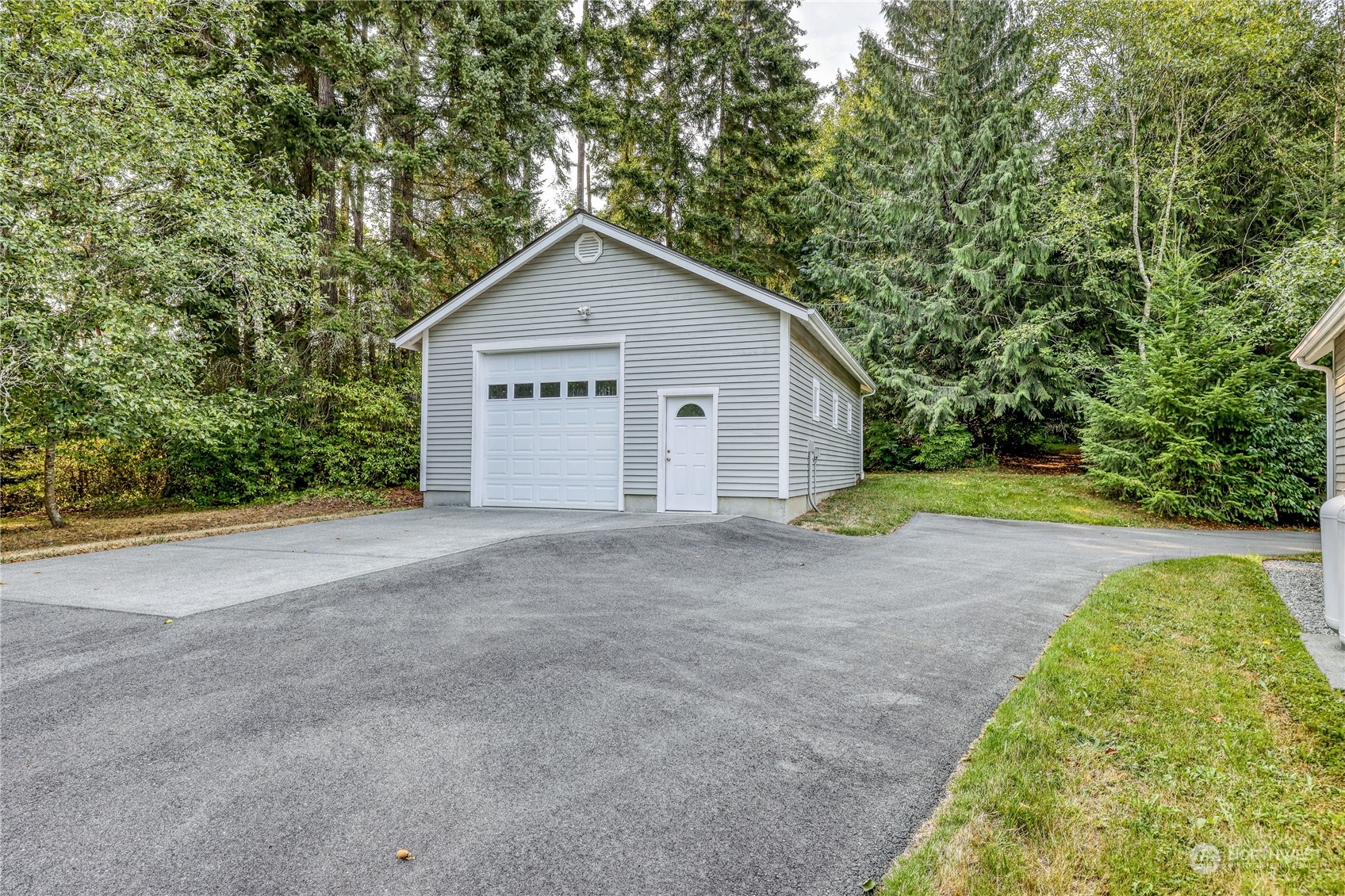 5701 Northeast Gunderson Road Poulsbo, WA 98370 - Photo 17 of 40 a view of a house with a yard and garage