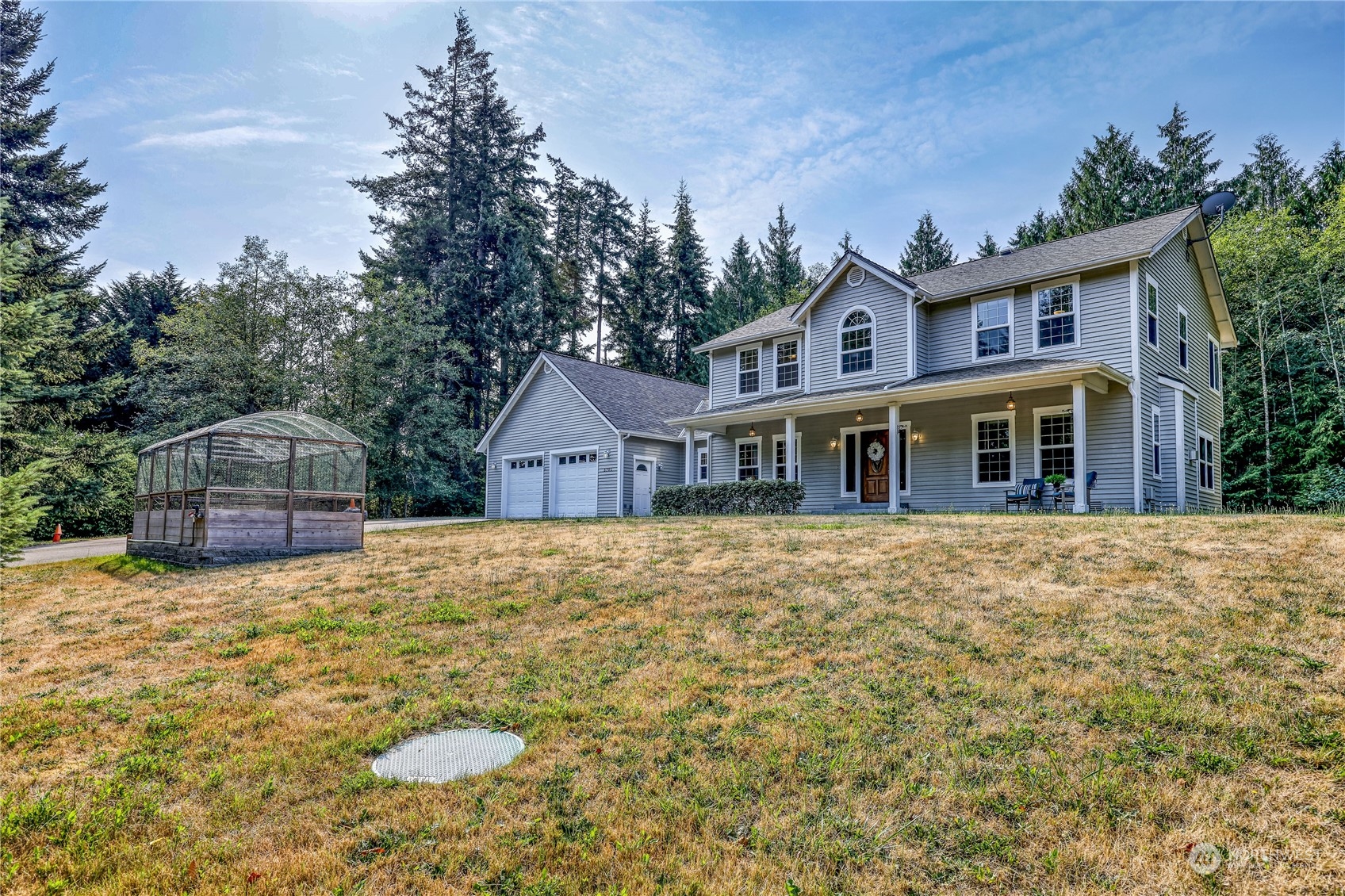 5701 Northeast Gunderson Road Poulsbo, WA 98370 - Photo 32 of 40 a front view of a house with yard and trees