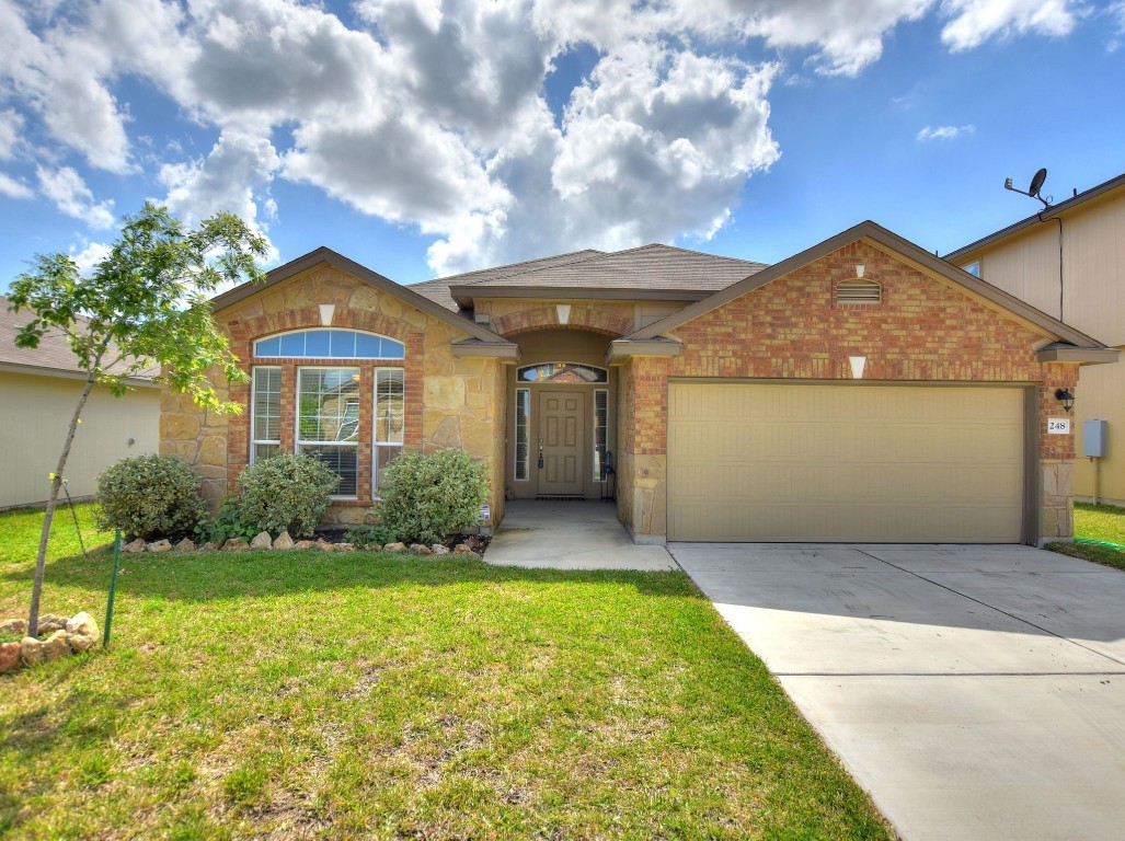 a front view of a house with a yard and garage