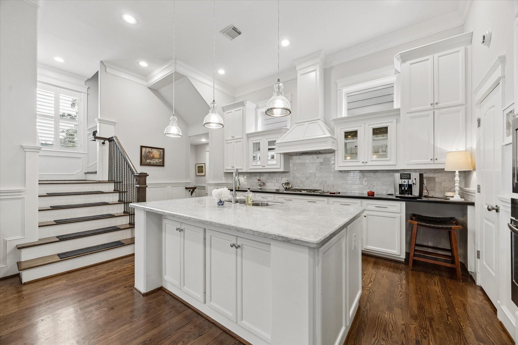 609 Rutland Street, Unit A Houston, TX 77007 - Photo 13 of 30 a kitchen with stainless steel appliances granite countertop a sink stove and white cabinets with wooden floor