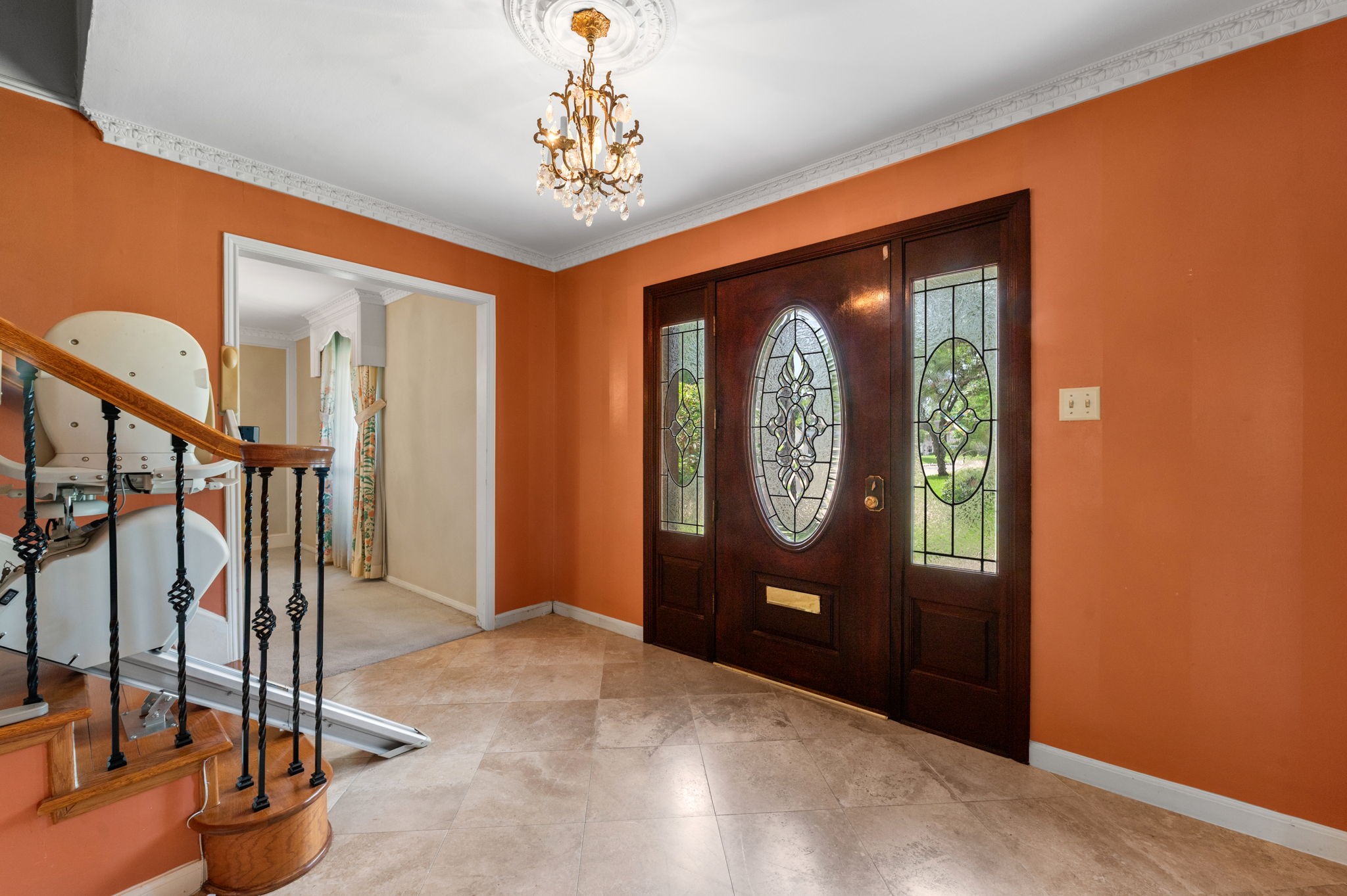 Grand entry has travertine tile look flooring, crown molding