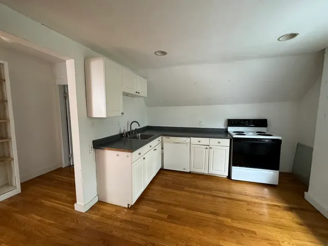 a kitchen with granite countertop a refrigerator and a stove