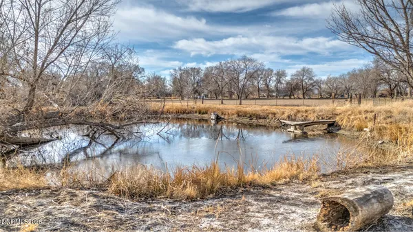 a view of a white house with a yard patio and table
