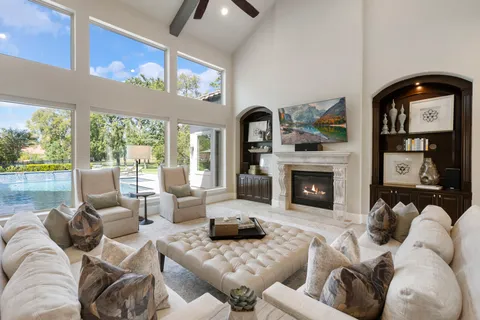 a living room with furniture a fireplace and a floor to ceiling window