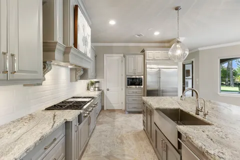 a kitchen with stainless steel appliances granite countertop a sink stove and refrigerator