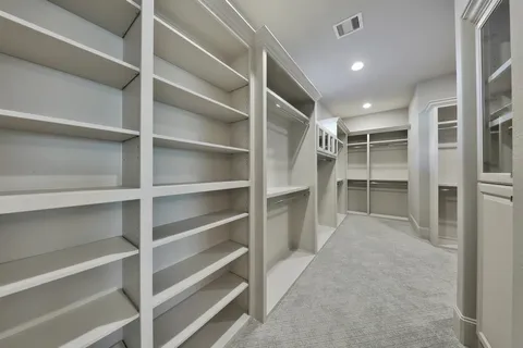 a view of walk in closet with empty racks