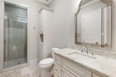 a bathroom with a granite countertop sink toilet and shower
