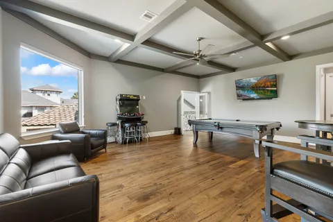 a living room with furniture and a flat screen tv with kitchen view