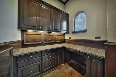a kitchen with granite countertop a sink and cabinets
