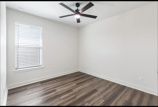 a view of a room with wooden floor and a window