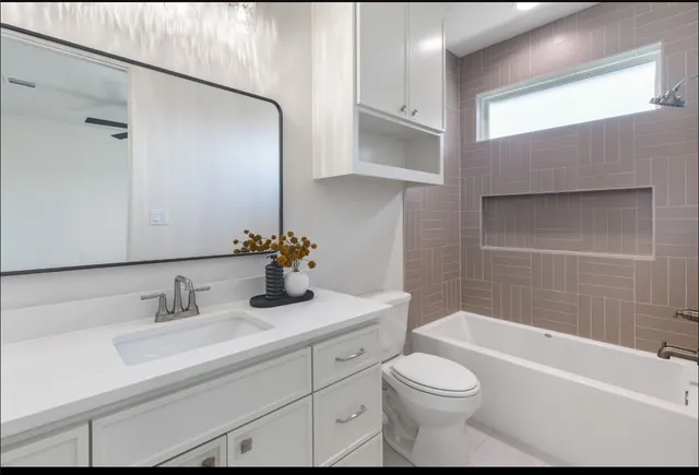 a bathroom with a sink a toilet and shower