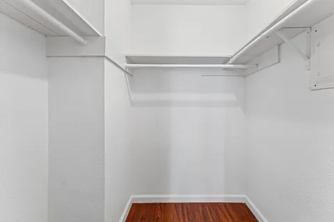 a view of walk in closet with empty racks