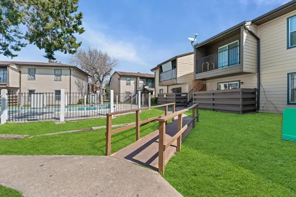a view of an house with backyard and a tree