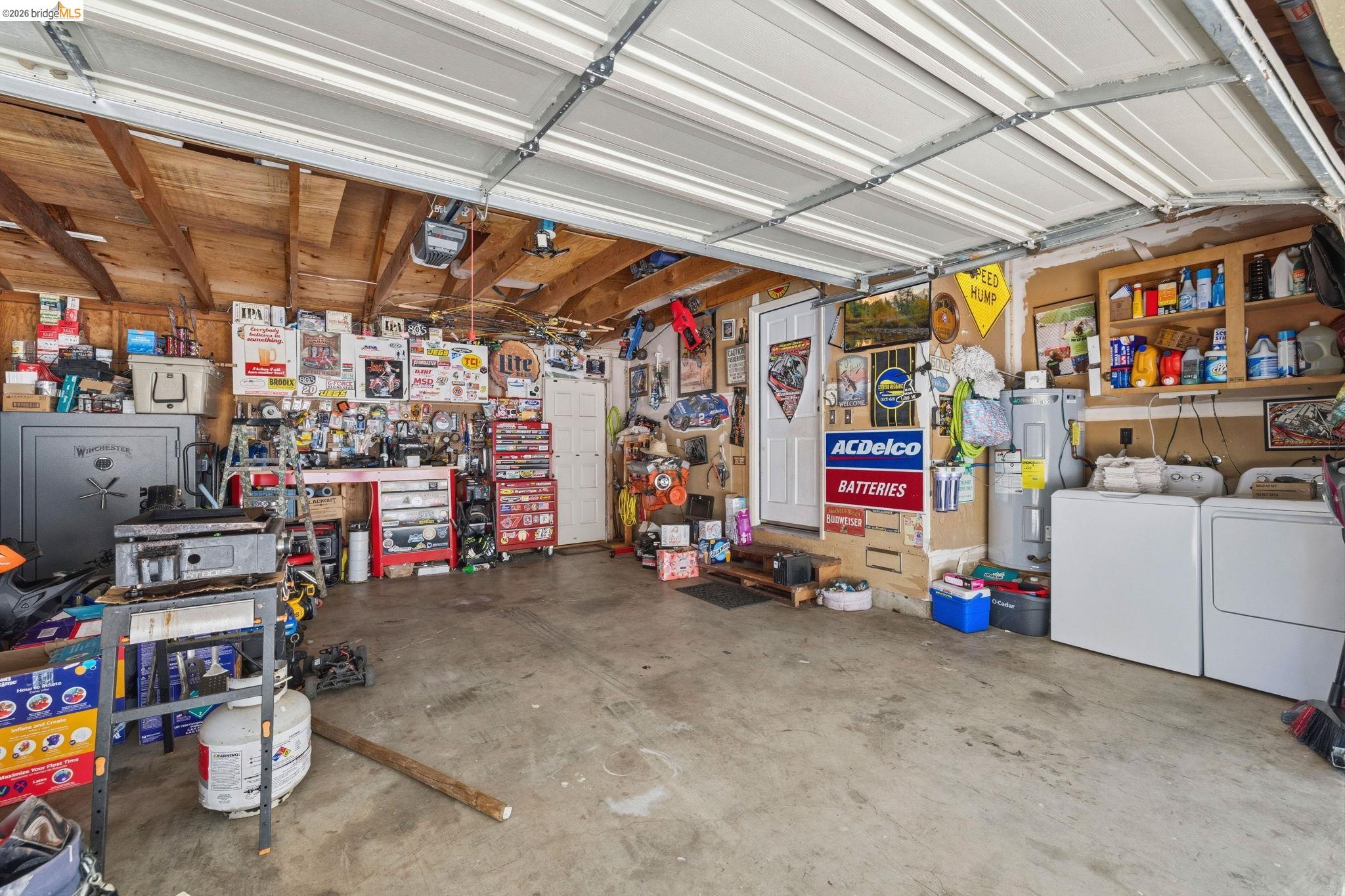19059 Raboul Court Groveland, CA 95321 - Photo 19 of 21 Two-car garage featuring a concrete floor, exposed wood beam ceiling, and a paneled garage door
