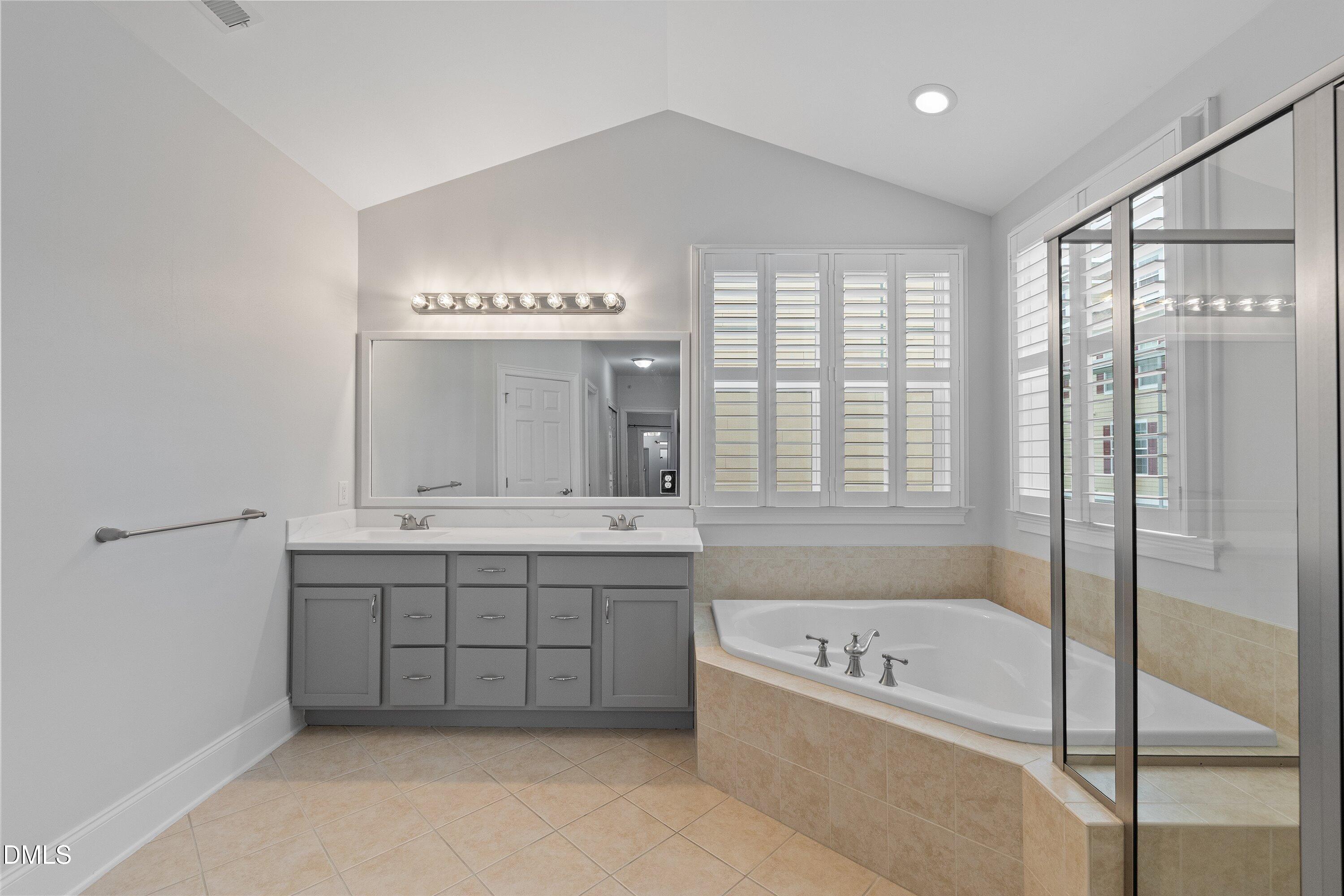 9211 Calabria Drive, Unit 205 Raleigh, NC 27617 - Photo 43 of 55 a bathroom with a tub sink and mirror