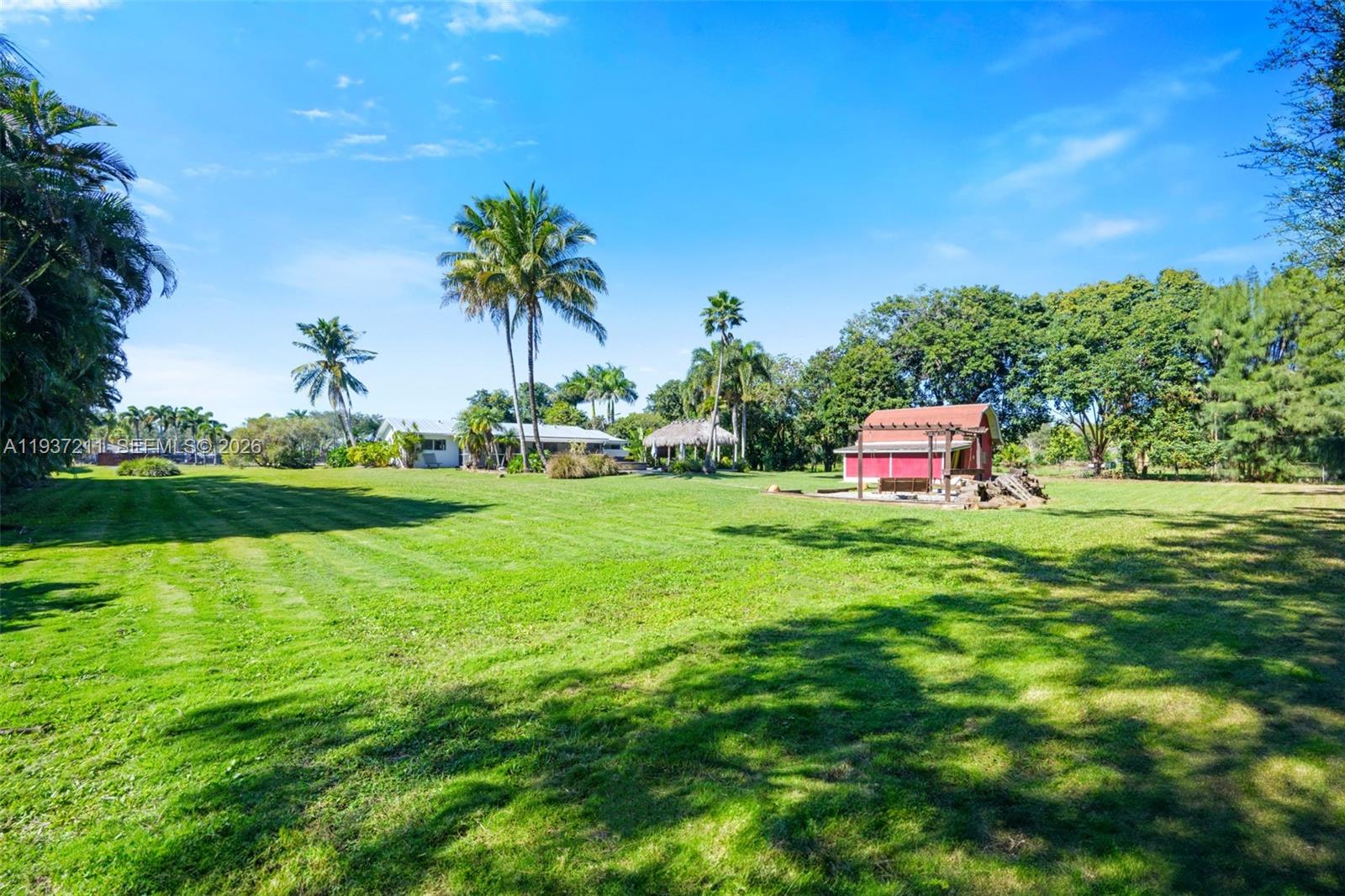 5300 Southwest 162nd Avenue Southwest Ranches, FL 33331 - Photo 38 of 43 a backyard of a house with table and chairs plants and large trees