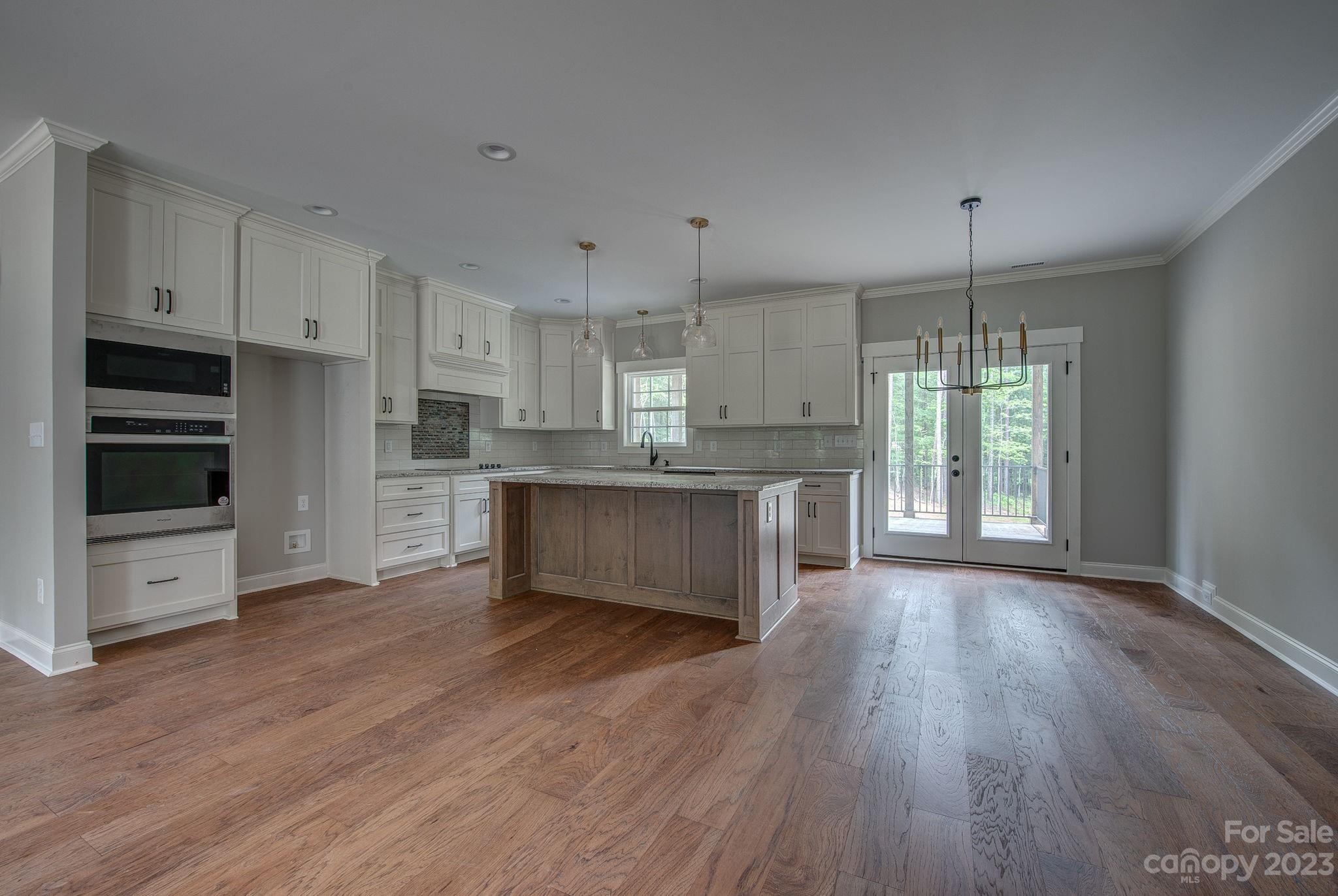 2911 Sparrow Springs Road Gastonia, NC 28052 - Photo 14 of 31 a large kitchen with cabinets wooden floor and stainless steel appliances