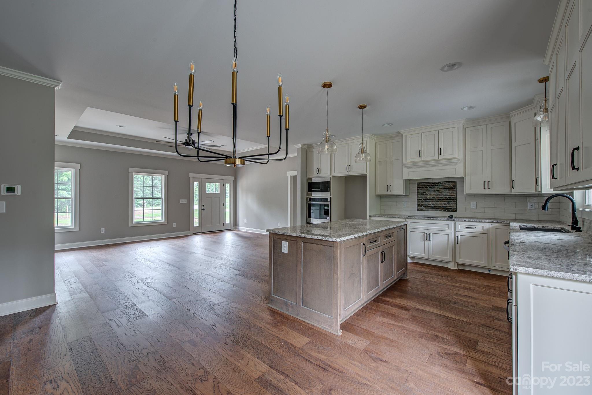 2911 Sparrow Springs Road Gastonia, NC 28052 - Photo 15 of 31 a large kitchen with stainless steel appliances granite countertop a stove a sink dishwasher and a wooden floor