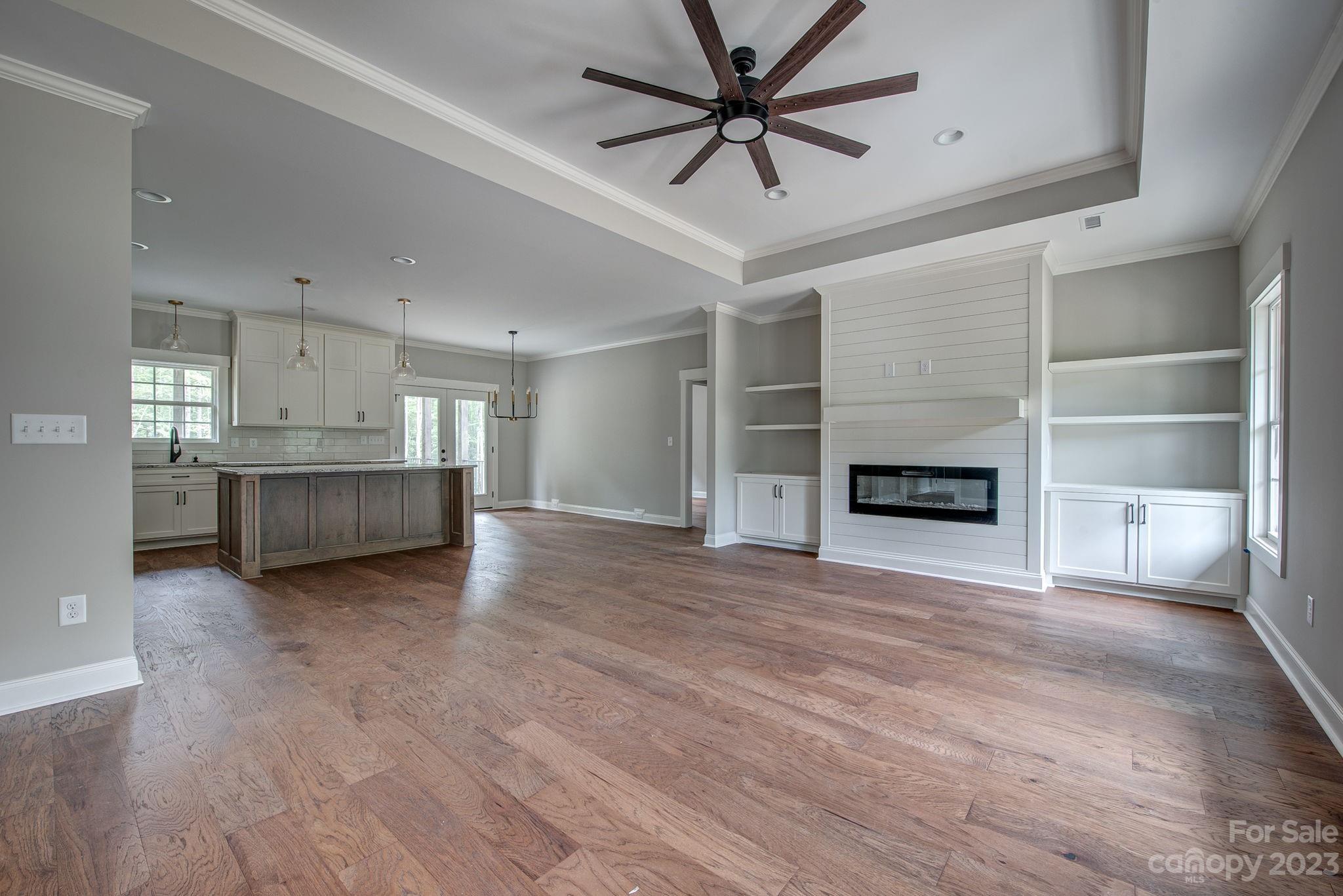 2911 Sparrow Springs Road Gastonia, NC 28052 - Photo 7 of 31 a view of a livingroom with a fireplace a ceiling fan a kitchen and windows