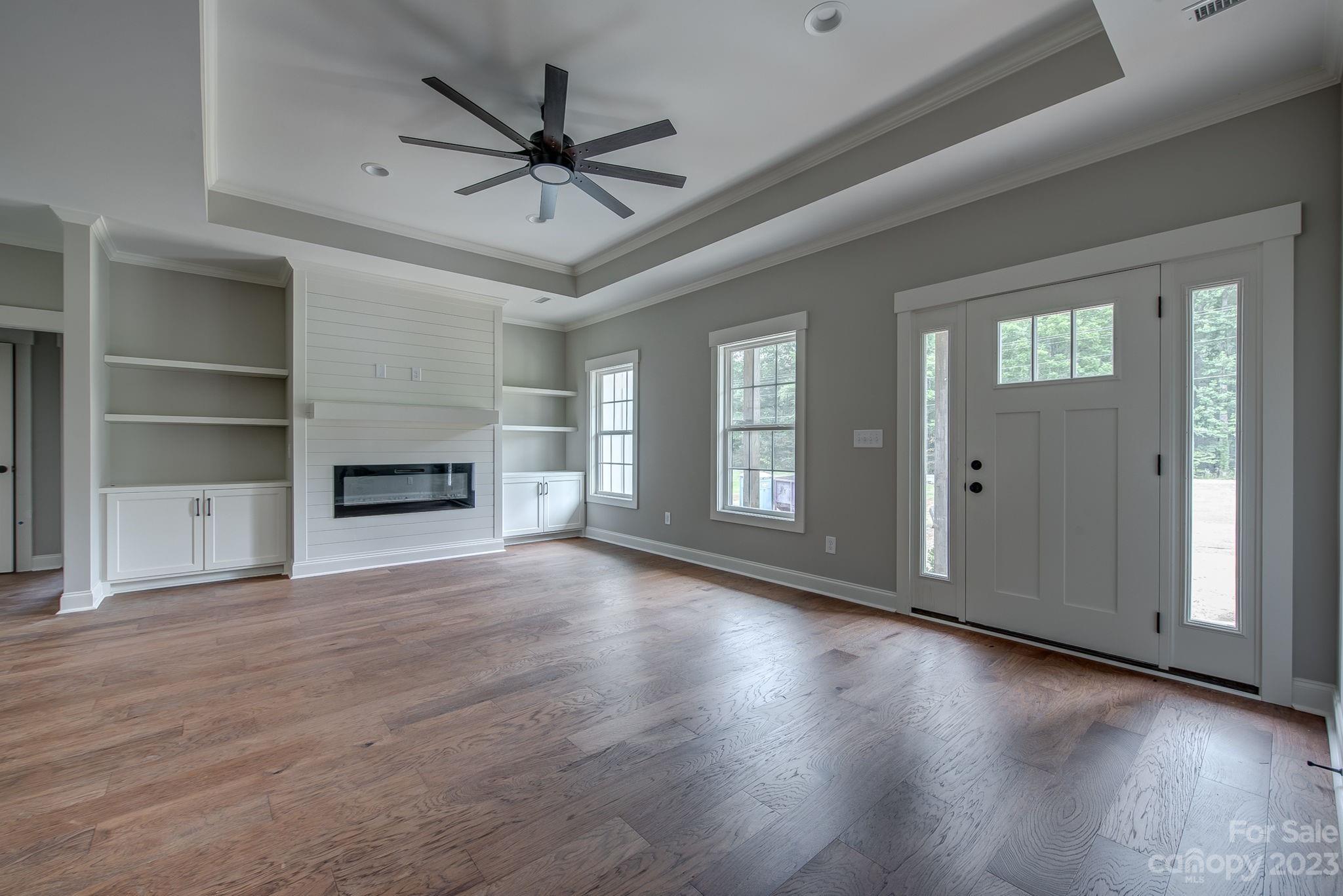 2911 Sparrow Springs Road Gastonia, NC 28052 - Photo 10 of 31 an empty room with wooden floor a ceiling fan and windows