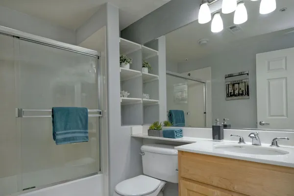 a bathroom with a granite countertop sink mirror and toilet