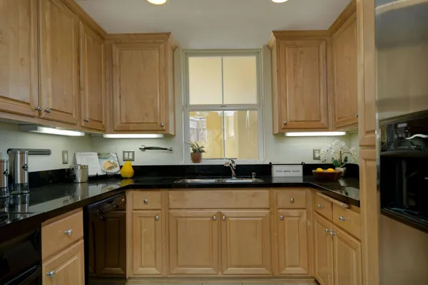 a kitchen with granite countertop a sink a stove and cabinets