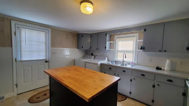 a kitchen with a sink cabinets and wooden floor
