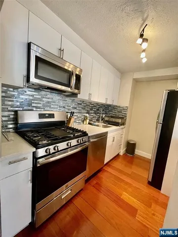 a kitchen with stainless steel appliances granite countertop a stove and a microwave