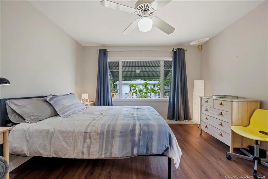 120 Southwest 5th Street Stuart, FL 34994 - Photo 17 of 35 a bedroom with a bed a chandelier and a window