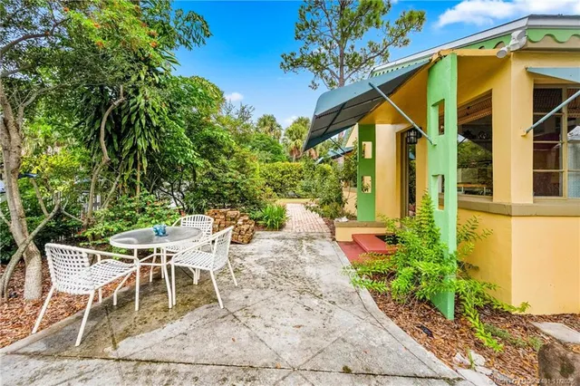 a view of patio with table and chairs and potted plants