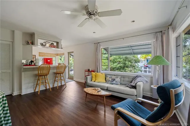 a living room with patio furniture and a flat screen tv