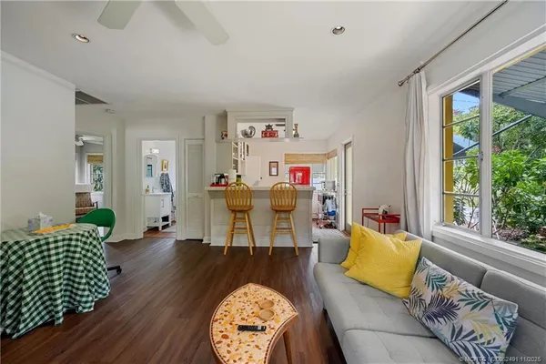 a living room with patio furniture and a flat screen tv