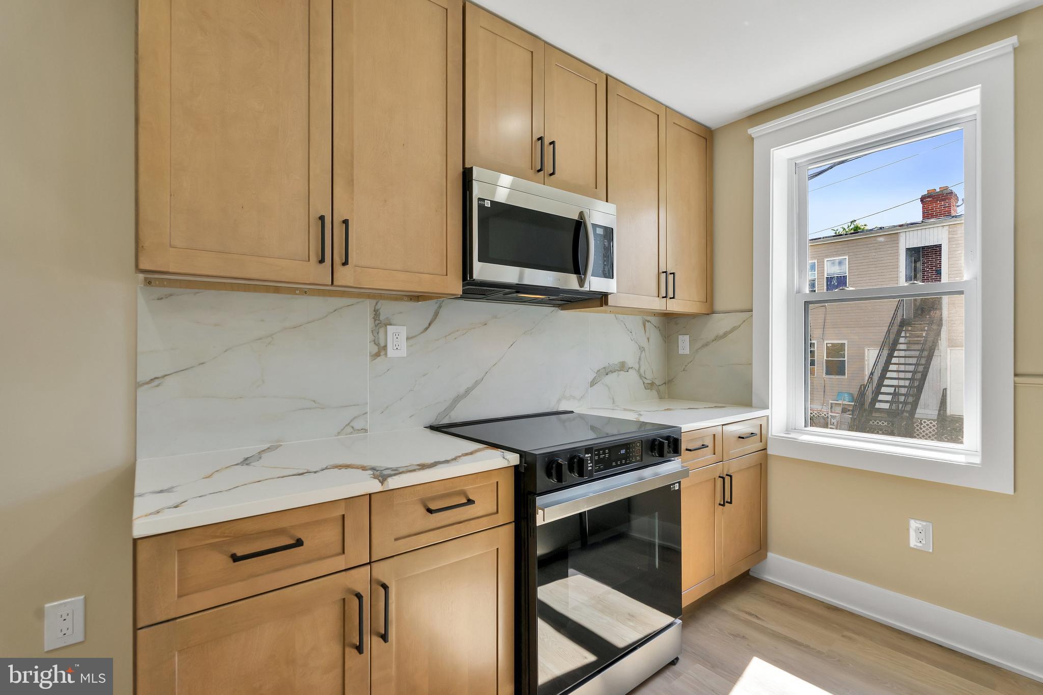1274 Meigs Place Northeast Washington, DC 20002 - Photo 10 of 57 a kitchen with stainless steel appliances granite countertop a stove a sink and a microwave