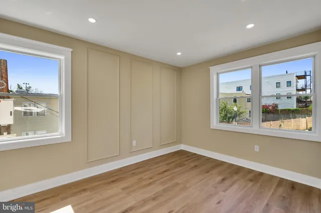 a view of a hallway with wooden floor and a bathroom