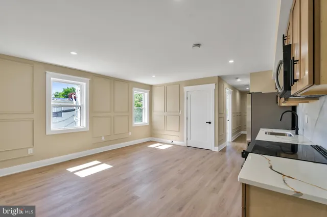 a kitchen with stainless steel appliances granite countertop white cabinets a sink a stove and a refrigerator