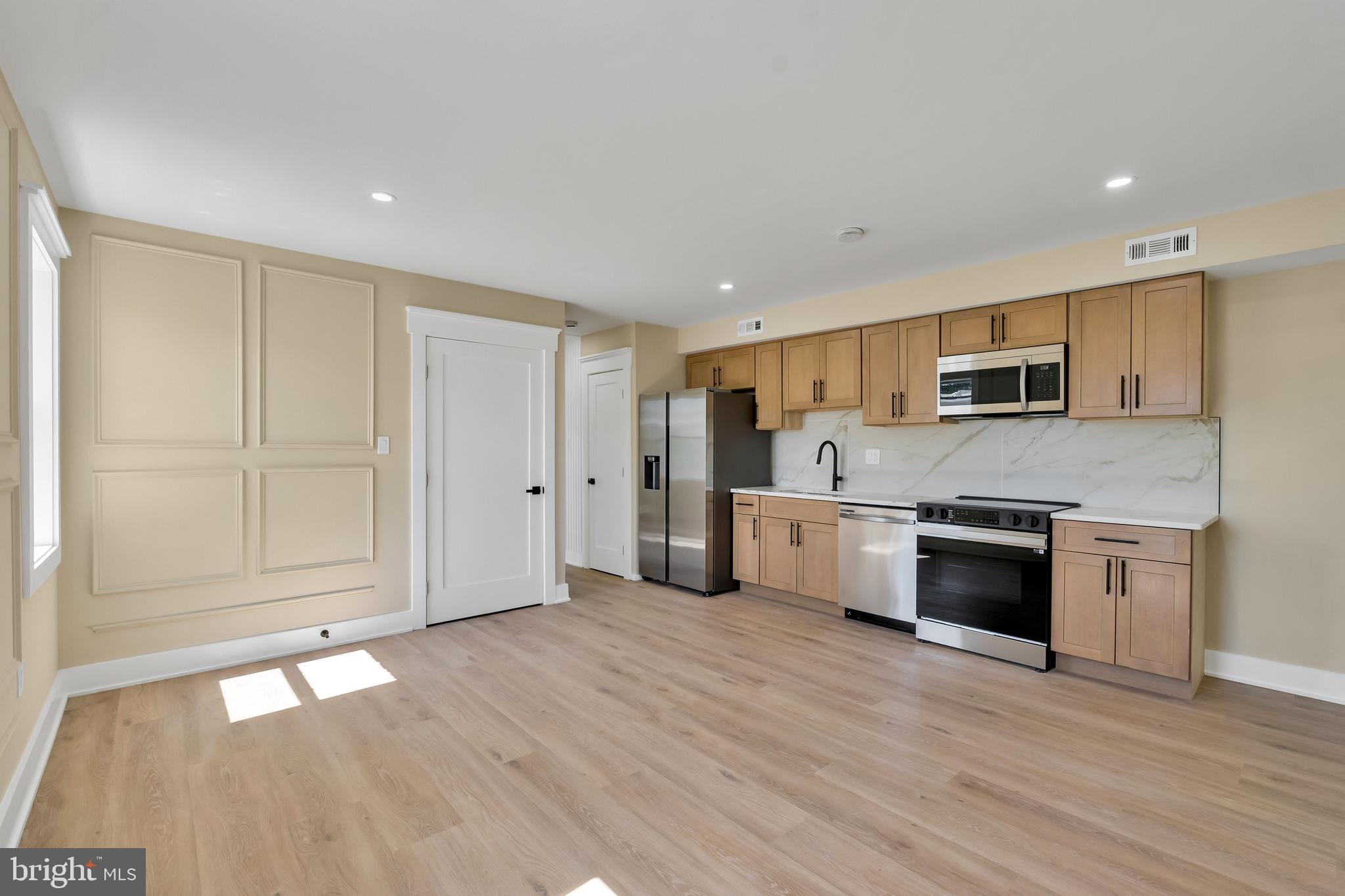 1274 Meigs Place Northeast Washington, DC 20002 - Photo 43 of 57 a large kitchen with stainless steel appliances granite countertop a stove a sink and a refrigerator