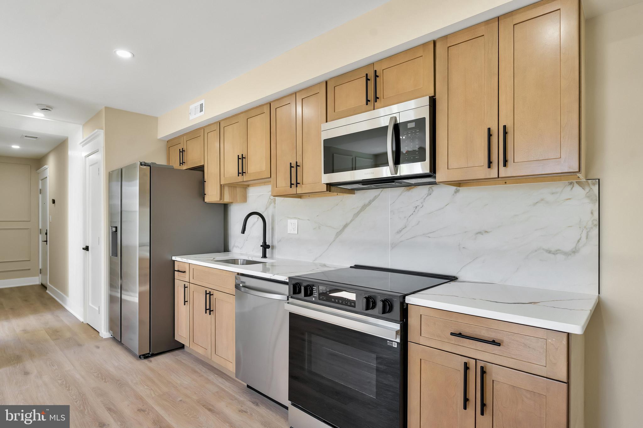 1274 Meigs Place Northeast Washington, DC 20002 - Photo 46 of 57 a kitchen with stainless steel appliances granite countertop white cabinets a sink a stove and a refrigerator