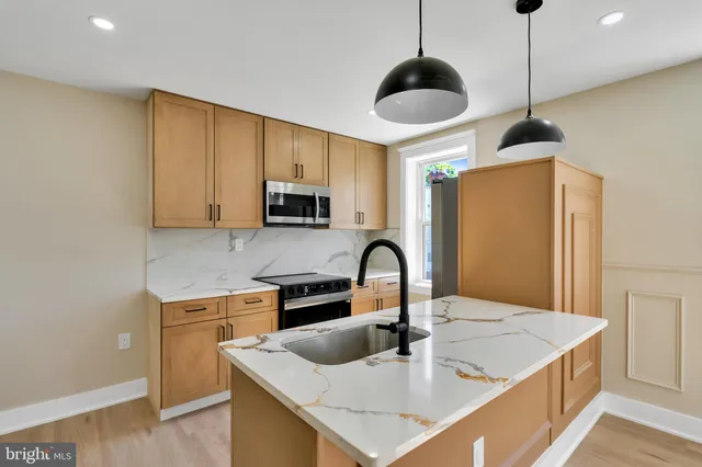 a kitchen with stainless steel appliances granite countertop a sink a stove and a refrigerator