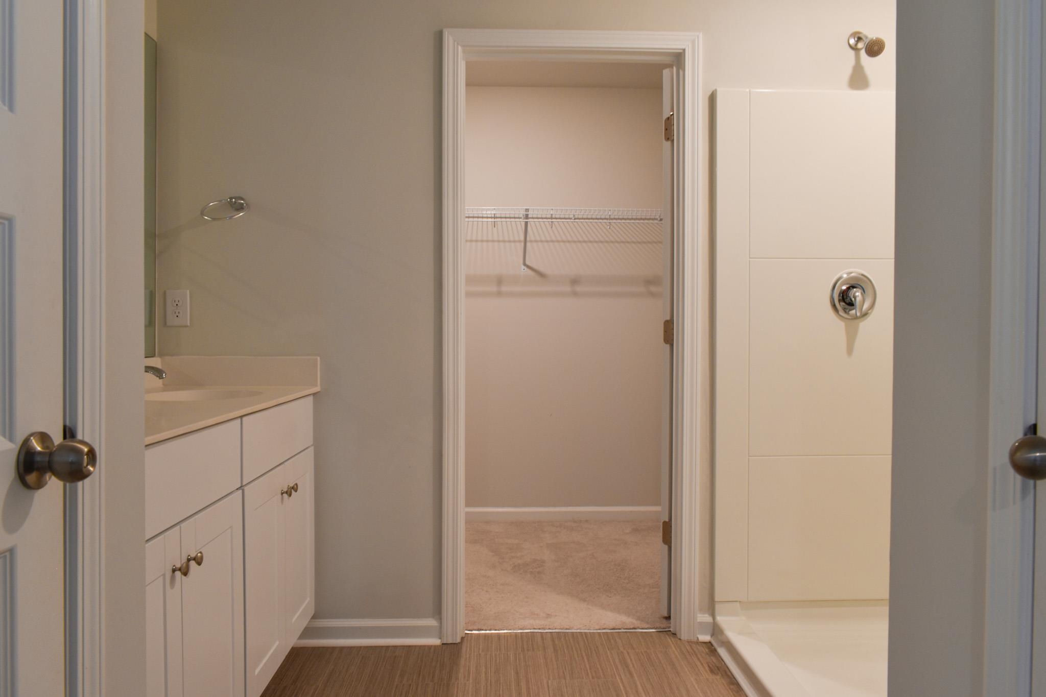 1057 Saltgrass Way Myrtle Beach, SC 29588 - Photo 15 of 23 Bathroom with a spacious closet, vanity, a shower, and light wood-type flooring
