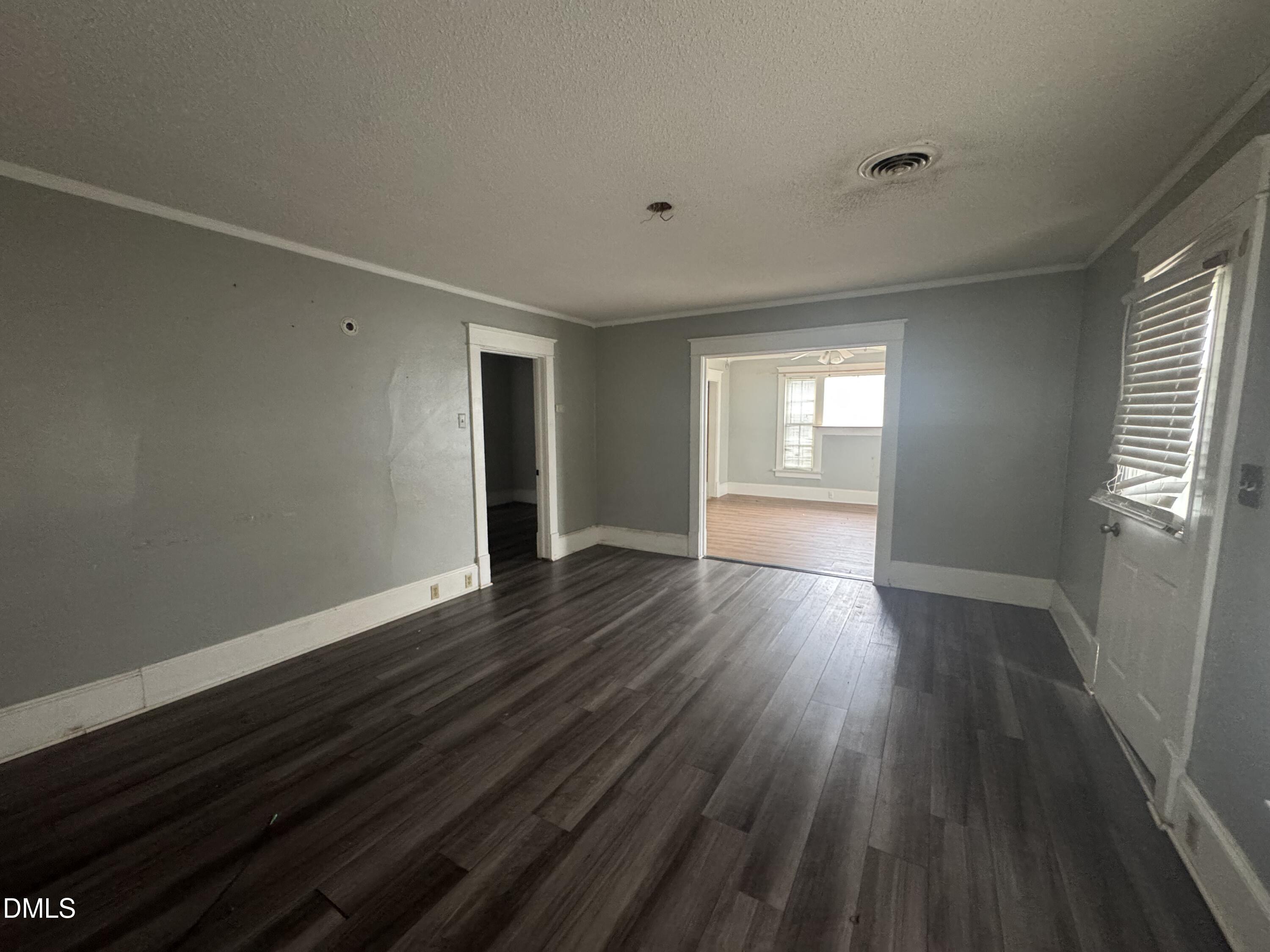 212 South 6th Street Smithfield, NC 27577 - Photo 13 of 17 a view of an empty room with wooden floor and window