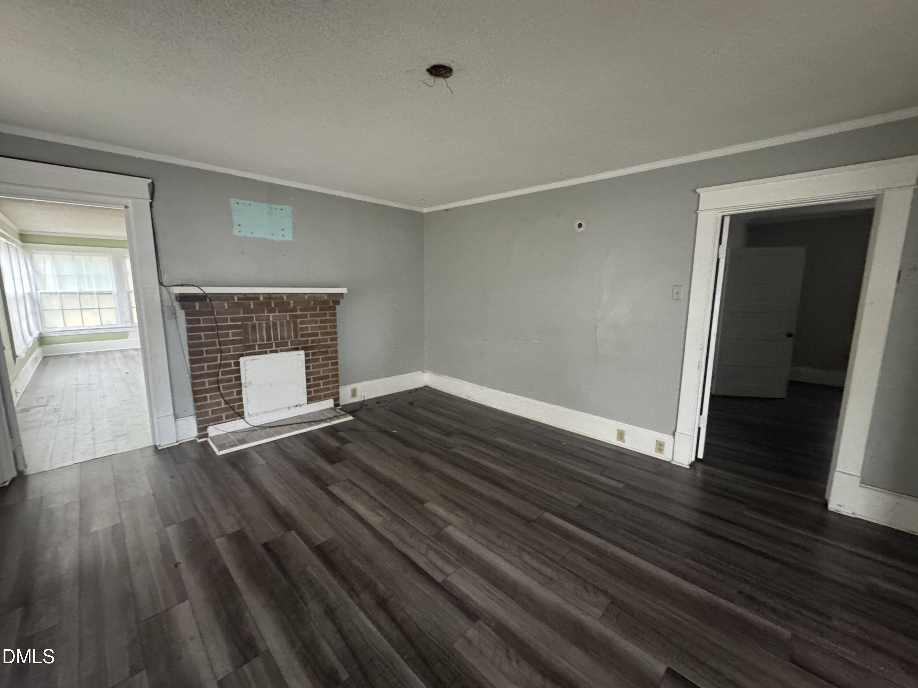212 South 6th Street Smithfield, NC 27577 - Photo 2 of 17 an empty room with wooden floor fireplace and windows