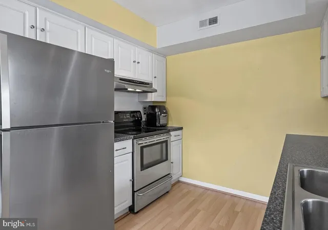 a kitchen with a refrigerator and a stove top oven