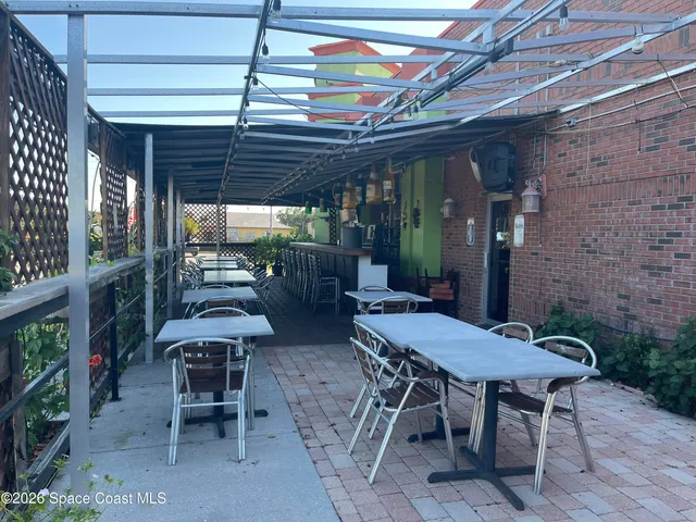 a view of a patio with a table and chairs and potted plants