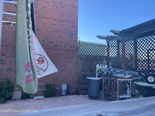 a brick building with a bench and potted plants