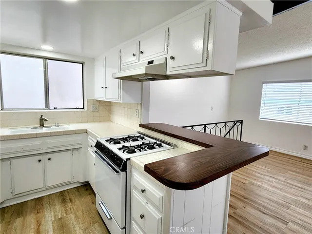 a kitchen with stainless steel appliances granite countertop a stove a sink and white cabinets