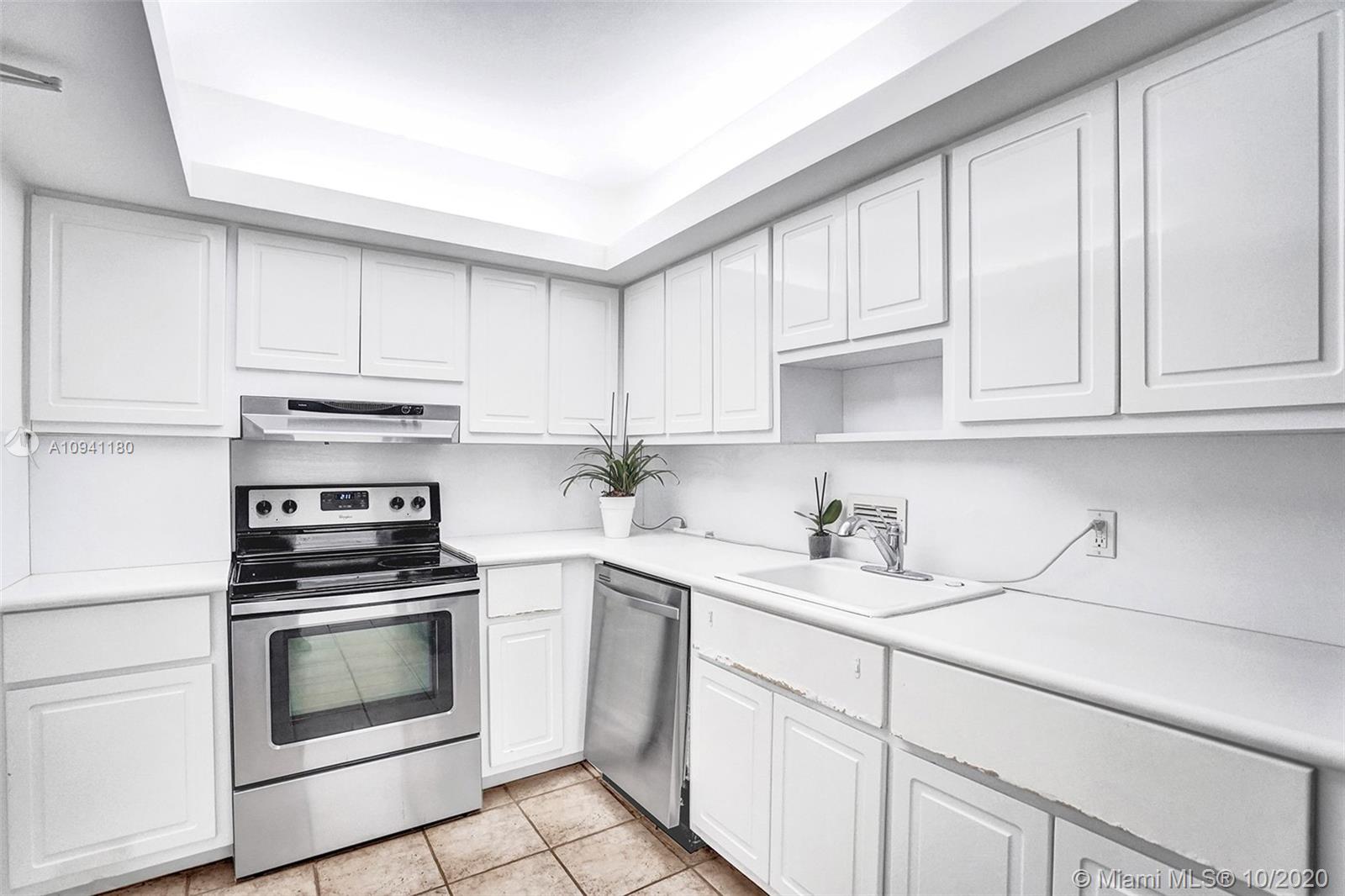 10185 Collins Avenue, Unit 818 Bal Harbour, FL 33154 - Photo 4 of 41 a kitchen with granite countertop white cabinets and white appliances