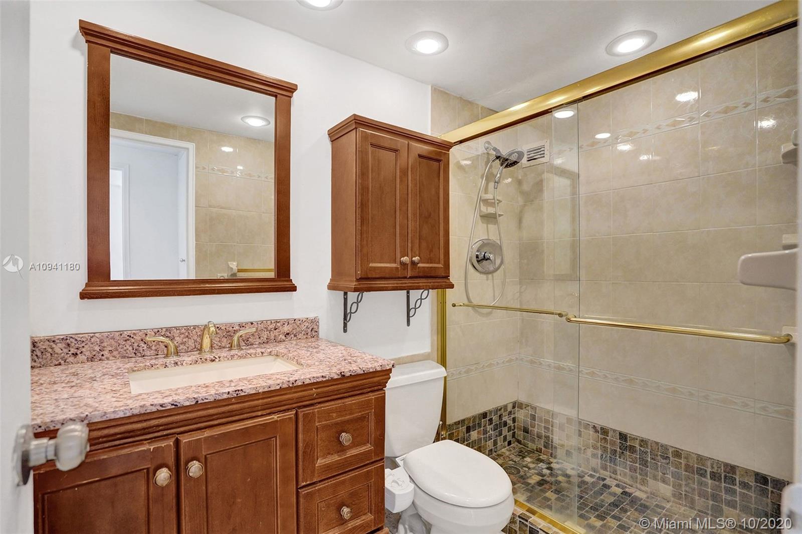 10185 Collins Avenue, Unit 818 Bal Harbour, FL 33154 - Photo 5 of 41 a bathroom with a granite countertop sink a toilet a mirror and shower