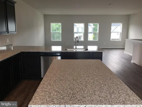 a kitchen with a sink and wooden floor