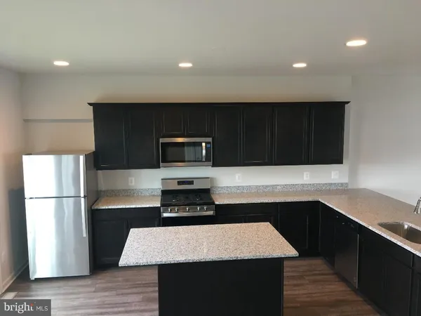 a kitchen with a sink dishwasher a stove and a refrigerator with wooden floor