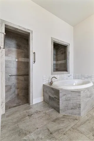 a bathroom with a tub sink and mirror
